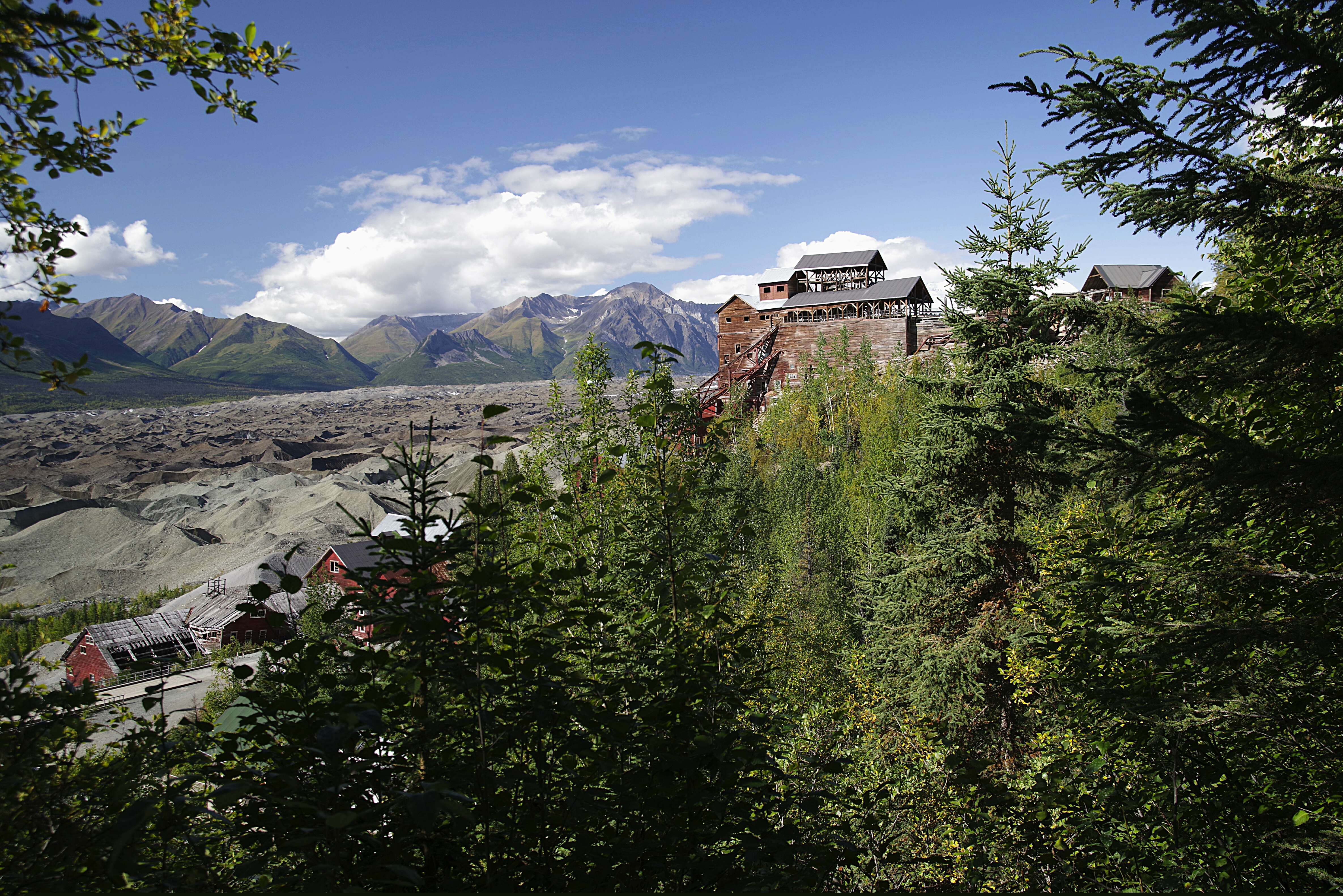 The 14-story red Kennecott Concentration Mill building overlooking the Kennicott Glacier in Wrangell-St. Elias National Park, Alaska