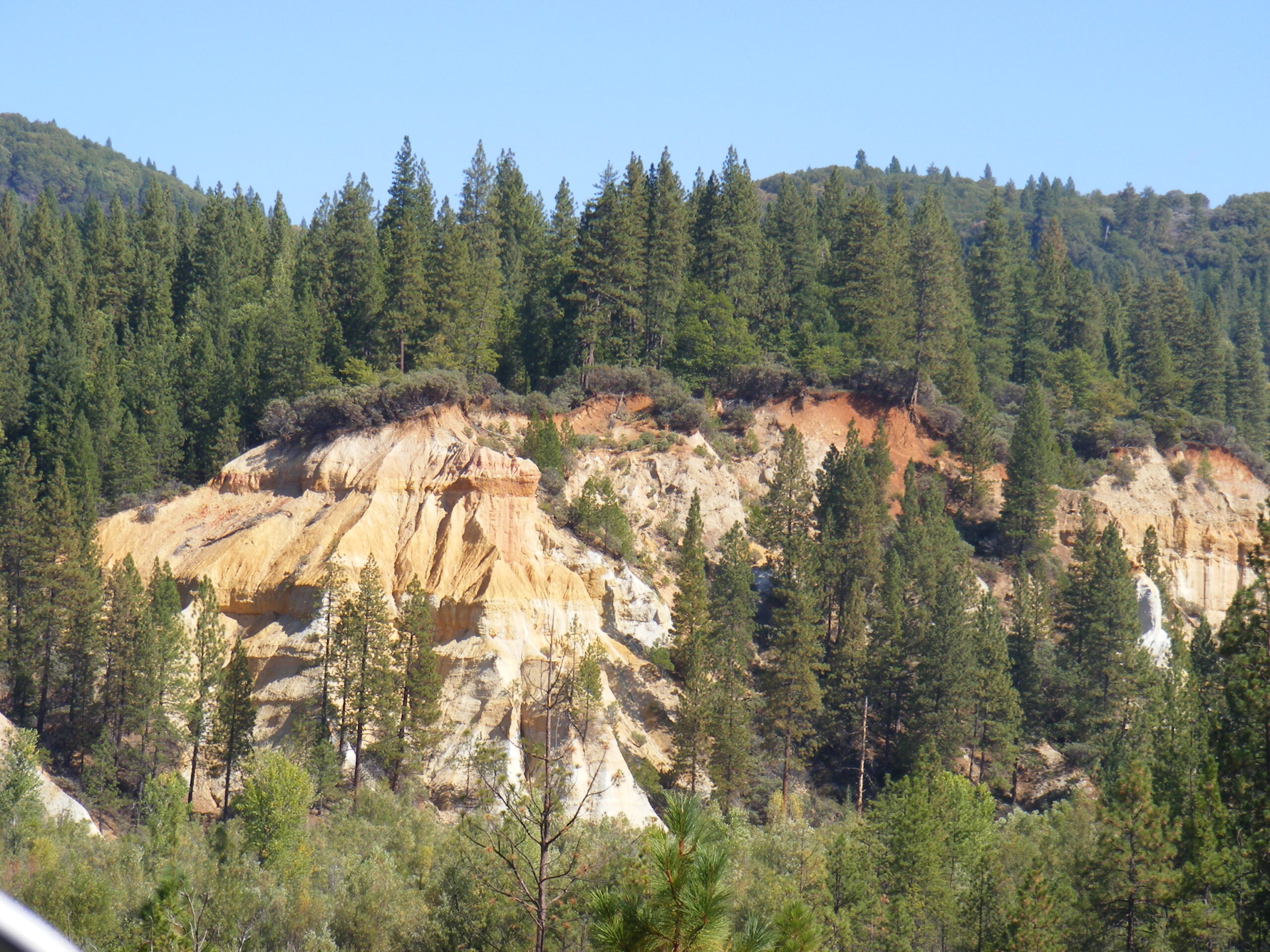 Eroded gold and pink hydraulic mining cliffs at Malakoff Diggins State Historic Park, North Bloomfield, California