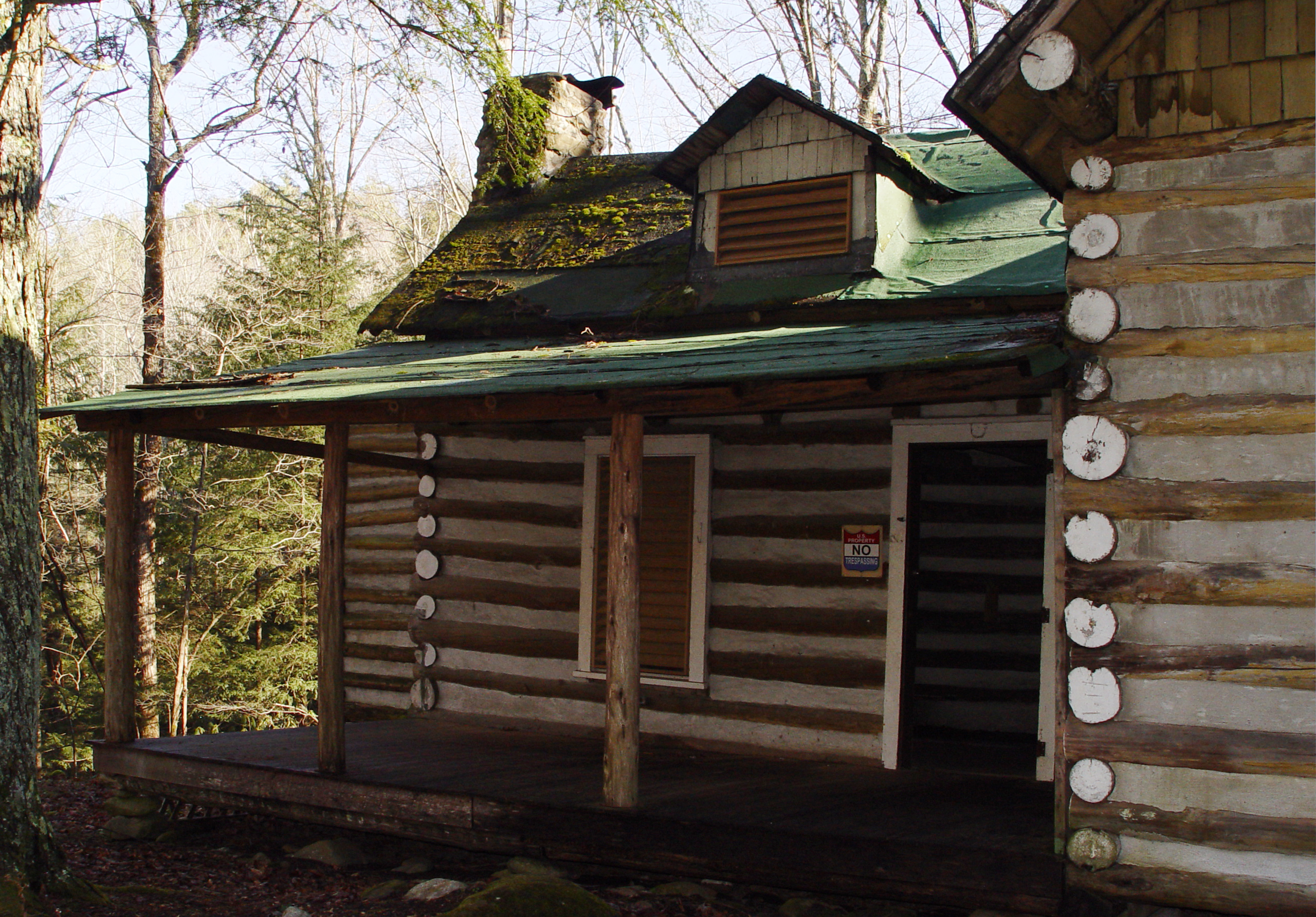 The Sneed cabin at Elkmont, a resort-era cottage with a stone chimney among the woods